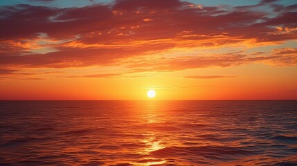 Obraz premium A stunning sunset over the ocean, with vibrant colors reflected on the water and cloud formations creating a serene atmosphere.