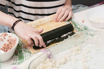 Rolling sushi with care a culinary creation happening in a bright kitchen filled with tasty ingredients