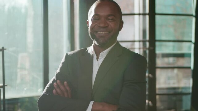 Happy middle-aged businessman 40s business man portrait in office successful entrepreneur posing crossed hands in corporate agency mature entrepreneur in sunny light male employer looking at camera