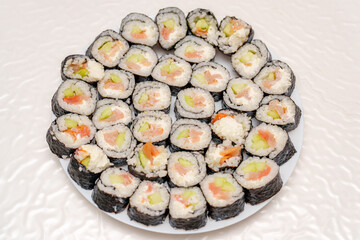 A platter of delicious sushi rolls with salmon and cucumber on a table