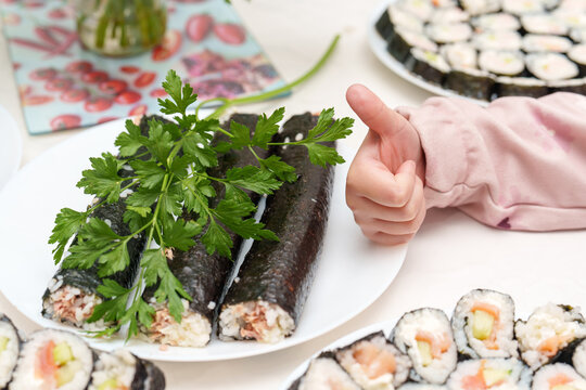 Homemade sushi gets a thumbs up from a budding chef on a bright day in the kitchen