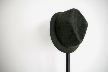 chapeau feutre vert suspendu sur pied