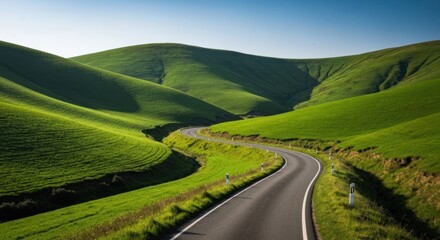 Winding road through lush green hills under a clear sky