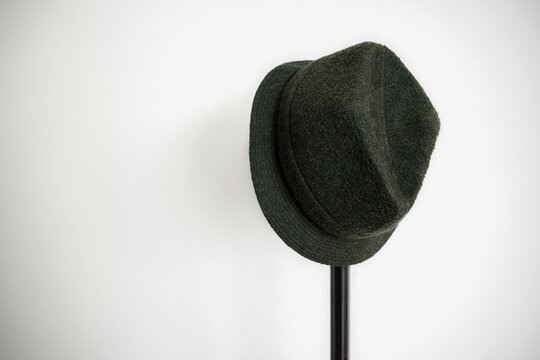 chapeau feutre vert suspendu sur pied