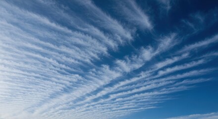 Wispy, striated clouds fill a deep blue sky