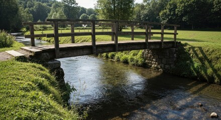 Wooden bridge spanning a small, clear stream in a verdant valley. Lush greenery surrounds the tranquil waterway