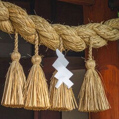 Traditional Japanese Shimenawa Rope with Shide Paper Decorations at a Shinto Shrine Entrance.