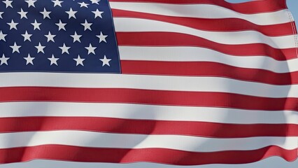 Obraz premium The United States flag with stars and stripes waving proudly in the wind against a clear blue sky, a symbol of patriotism and freedom