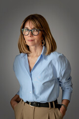 Blond haired confident woman standing against isolated background