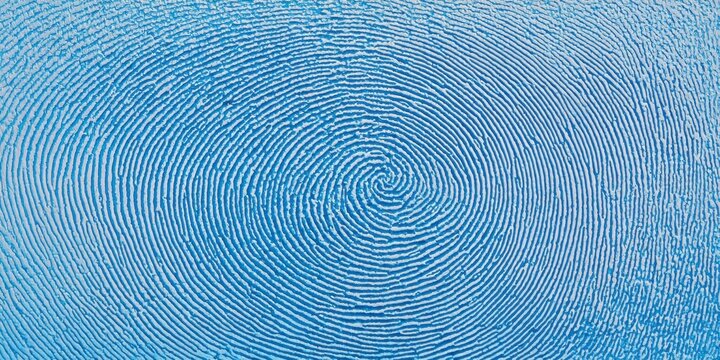 Close up of a distinctive whorl fingerprint pattern in vibrant blue color - Powered by Adobe