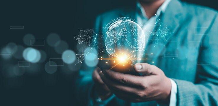 A business professional holding a smartphone with a glowing digital globe and network connections, symbolizing global communication, connectivity, data exchange, digital transformation, worldwide - Powered by Adobe
