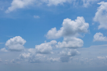 Obraz premium A fluffy white cloud in the sky naturally resembles the shape of a dog, standing out against the bright blue background and creating a playful and imaginative scene.