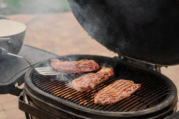 Selective focus.barbecuing steaks on the grill. Future steak and barbecue. Meat in hand on the grill background. 