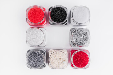 Polymer products of different colors containers on a white background. Polymers and polystyrene. Chemical industry.Glass jars top view