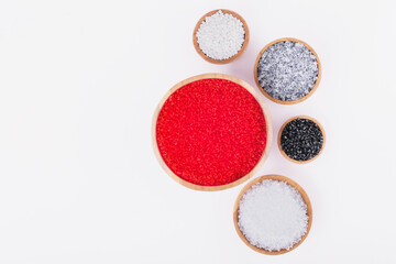 Polymer products of different colors in wooden containers on a white background. Polymers and polystyrene. Chemical industry