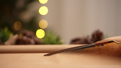 Golden Scissors Cutting Brown Paper for Gift Wrapping