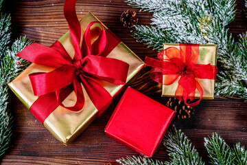 gifts boxes with fir branches on wooden background top view