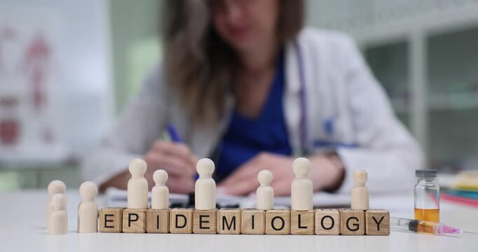 Wooden blocks spell word Epidemiology with people wooden figures lining. Public health doctor maps infection routes explaining epidemiology mode