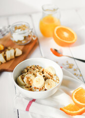 healthy breakfast bowl of yogurt with granola and banana