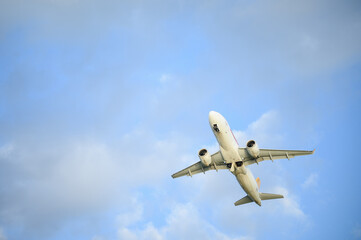 White plane approaches landing zone under clear sky. Unmarked commercial jet takes off or lands against clear blue sky.
