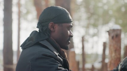 equestrian equipment arrangement, individual carefully setting up horse equipment beside fencing, stable assistant methodically arranging horse riding gear beneath gentle forest illumination