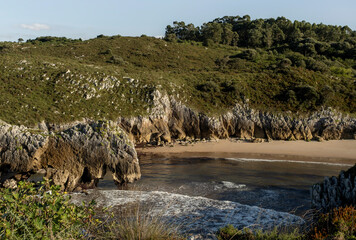 Sandy beach with sea arches in the Asturian coast