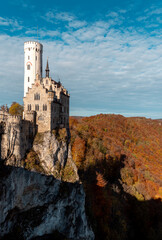 Medieval german castle on a cliff surrounded by a vibrant autumn forest