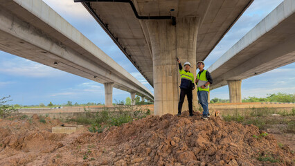 Obraz premium Construction workers assessing infrastructure urban site photographic capture outdoor setting ground-level perspective engineering insights