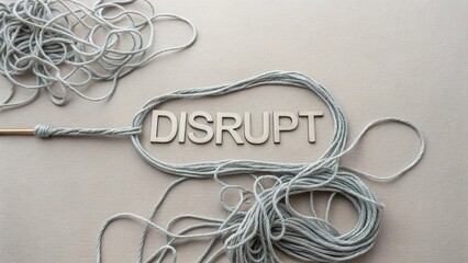 Flat lay of tangled thread and the word DISRUPT