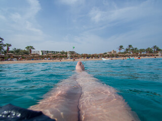 A first-person perspective of a person relaxing in the clear blue water of the Read Sea. Picture from Makadi Bay, Egypt