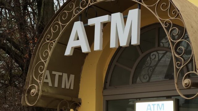 City sidewalk scene highlighting bank entrance with detailed metalwork and colorful autumn surroundings