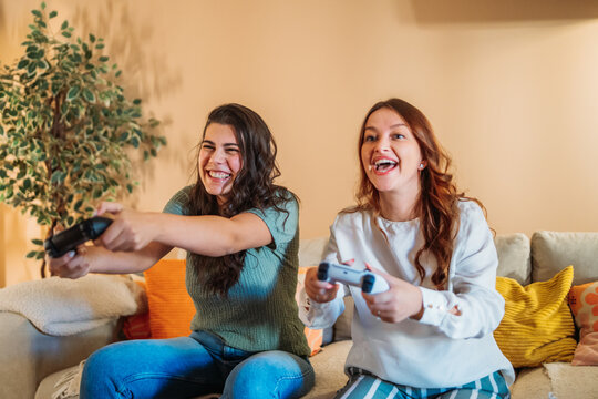Women friends laughing playing video games together