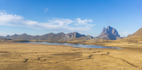 Aerial view of a mountain lake with a mountain range in the background on a clear day blue sky above