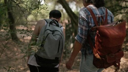 Couple with backpacks hiking in the forest