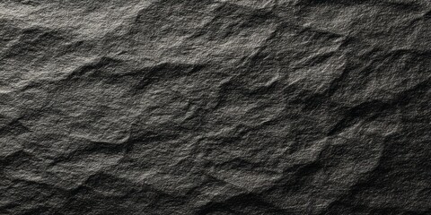 Dark gray rough stone surface presents deep texture under illumination