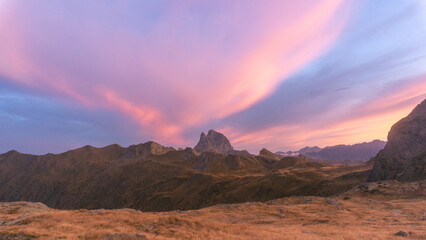 Dramatic mountain landscape with pink and blue sunset sky and rugged terrain in the foreground