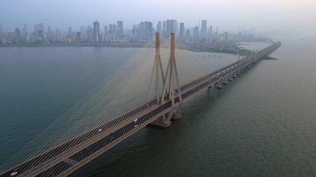 Aerial timelapse of traffic on the Bandra Worli Sea Link cable stayed bridge with the Mumbai skyline in the background in Mumbai, India.