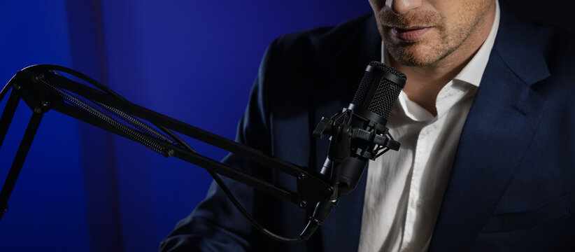 business podcast or radio interview recording. closeup of businessman talking in microphone in broadcasting studio. copy space
