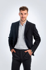 Confident young businessman standing against isolated white background