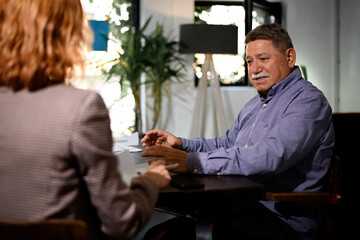 Businessman engaged in discussion with a colleague in a modern office environment during a daytime meeting