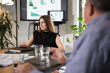 Business meeting with professionals discussing financial strategies in a modern office setting during daylight hours