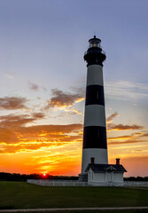 Near Nags Head in Cape Hatteras National Seashore, the historic Bodie Island Lighthouse stands against a sunrise sky over the North Carolina Outer Banks.
