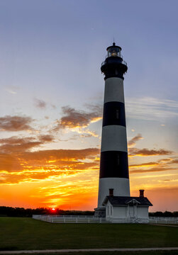 Near Nags Head in Cape Hatteras National Seashore, the historic Bodie Island Lighthouse stands against a sunrise sky over the North Carolina Outer Banks.