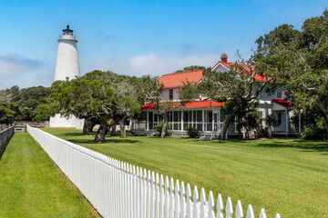 A white picket fence leads the eye past the keeper's house to the Ocracoke Lighthouse, America's second oldest standing lighthouse' on the southern tip of the Outer Banks of North Carolina.