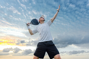 Padel player on the padel court with padel racket and ball in action. Open social tour template. Padel tennis player outdoors. Paddle tenis template for design ads with copy space.