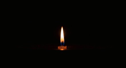 Flickering Candle Flame Illuminates Darkness, Creates Warm and Solitary Glow