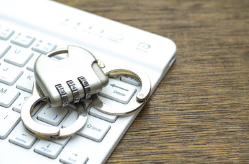 Cybercrime Lock Down: Padlock and Handcuffs on Keyboard Symbolizing Digital Security and Protection