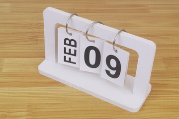 February, 09 on calendar on wooden table close-up.	