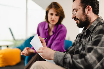 Business professionals discuss project ideas in a modern office space during a collaborative meeting on a sunny morning