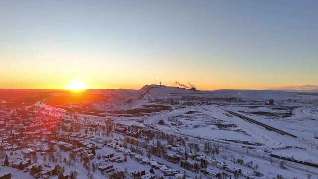 Kiruna, Sweden, aerial rotating view over the city and the iron ore mine, during high noon just before the polar night sets it. Winter, snow, ice, clear sky